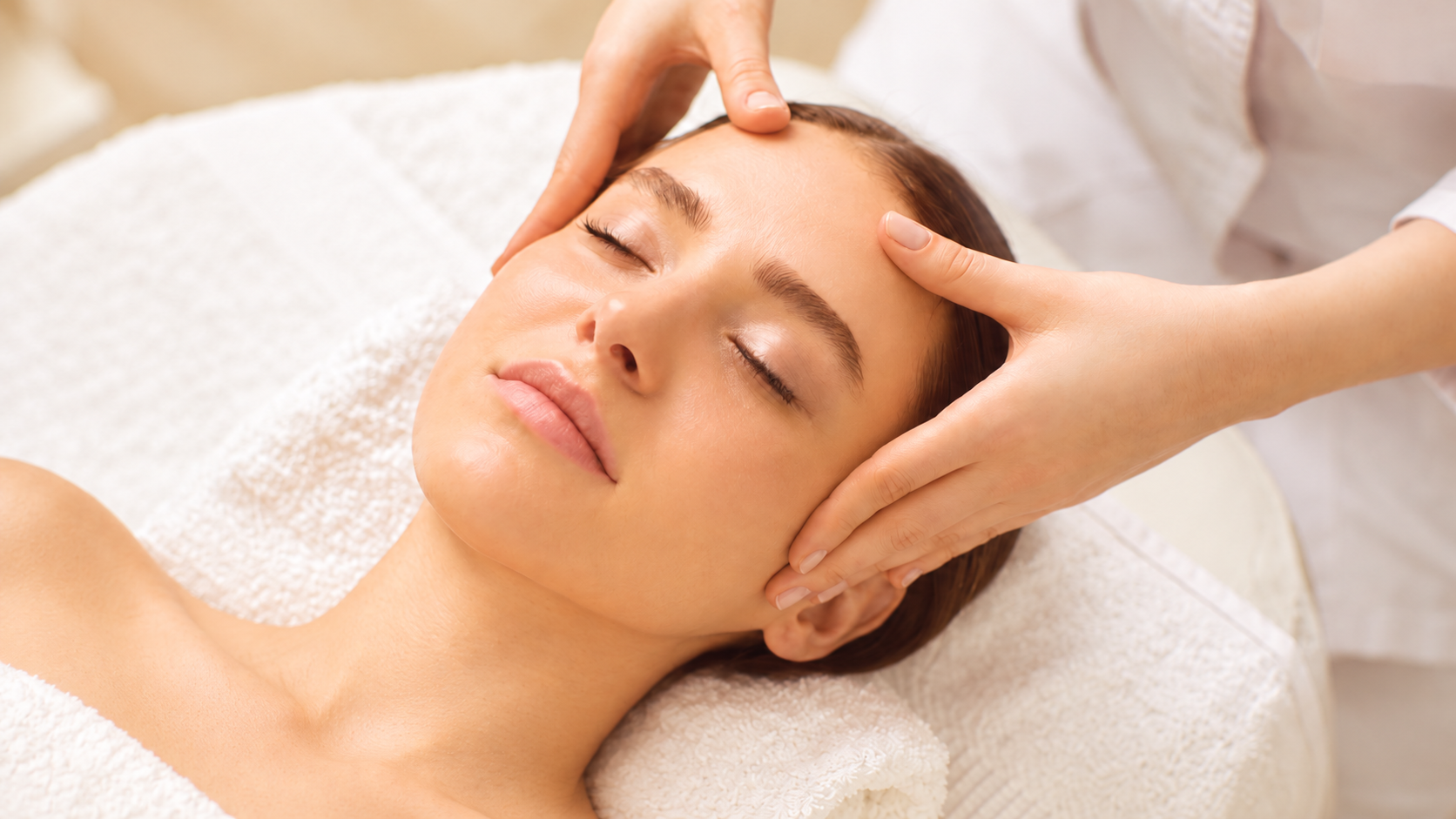 Illustration d’un massage du visage, les mains posées délicatement sur les tempes